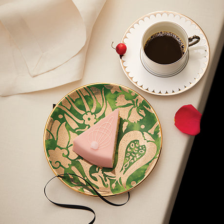 Decorative plate with a heart design on a table with a cup of coffee.